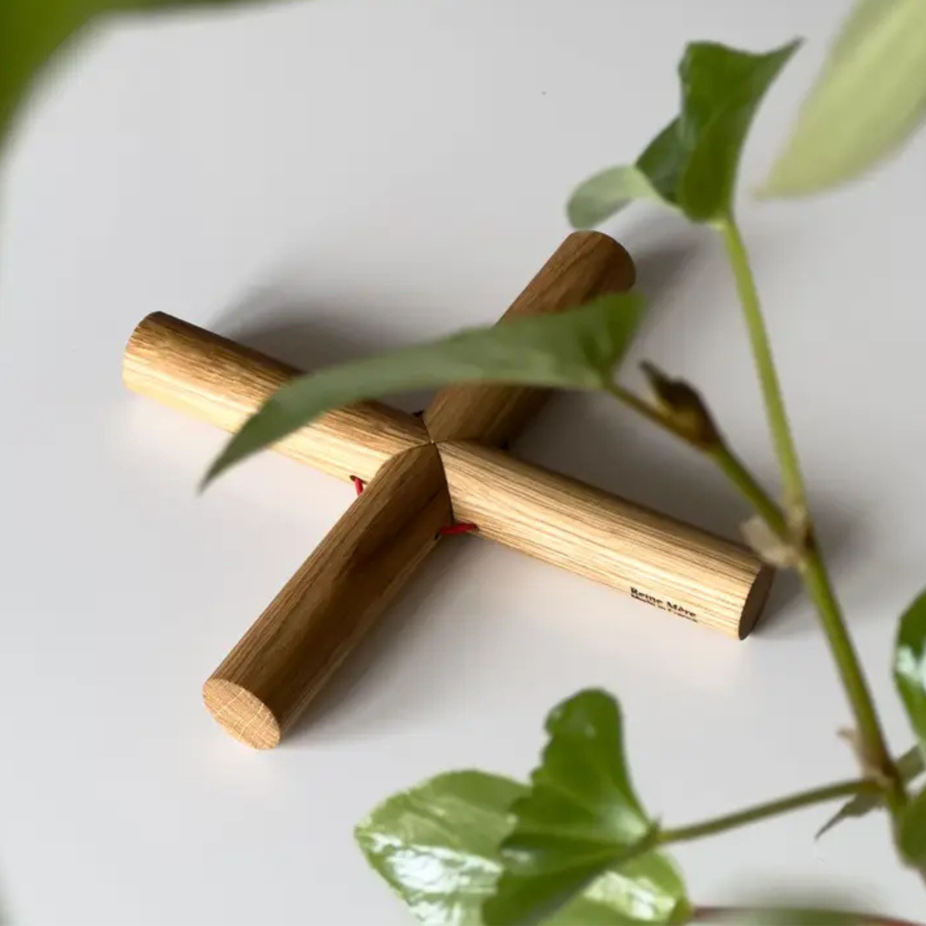 Dessous de plat moderne composé de billes de bois articulées formant un support stable et graphique.